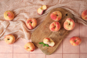 Wooden board with sweet fig peaches and mint on pink tile table