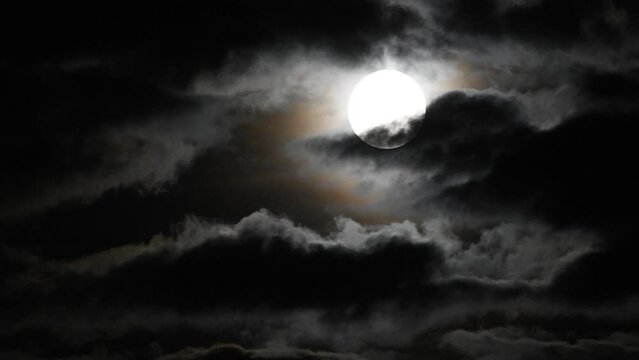 clouds moving slowly in front of full moon
