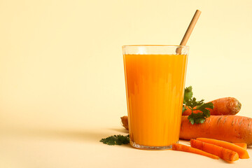 Glass of fresh carrot juice with parsley on orange background