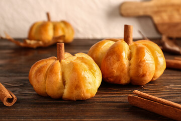 Tasty pumpkin shaped buns on table
