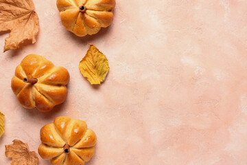 Tasty pumpkin shaped buns on beige background