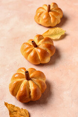 Tasty pumpkin shaped buns on beige background