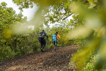 Outdoor Adventure: Man with Black Backpack and Woman with Blue Backpack Exploring the Mountain