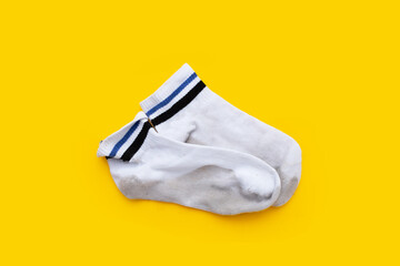 Dirty white socks on yellow background.