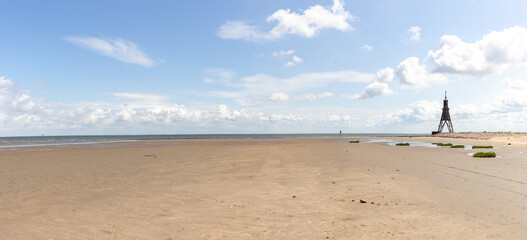Panoramic photo of a sandy beach on the North Sea in Cuxhaven, Germany. Northernmost point of Lower...