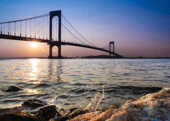 View of the Whitestone Bridge in Queens, New York City at sunset with the water of the Long Island Sound in view. - 640410420