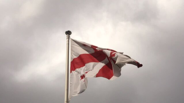 The flag of Georgia, also known as the five-cross flag, is one of the national symbols of Georgia waving in the wind from a flagpole.