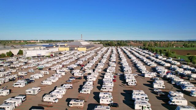 Row of modern campers parked in parking lot view from above at auto in annual exhibition of camper vans (Salone del Camper). Best option for travel feeling free. Parma, Italy - September 17, 2022. 4K