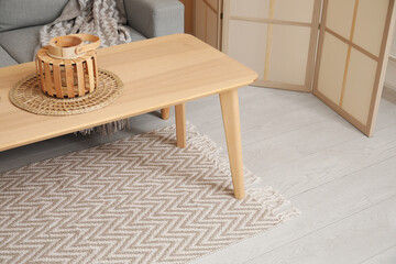 Fototapeta na wymiar Interior of living room with stylish rug and lantern on coffee table