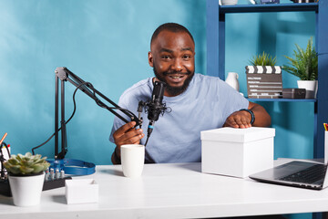 Smiling blogger announcing giveaway while streaming live in social media and looking at camera....