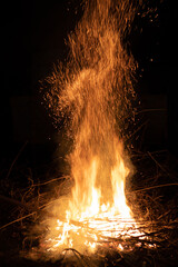 A high smooth stream of sparks from a fire. The background is black