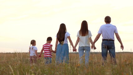 Large family with children raise up joined hands showing happiness at farmland