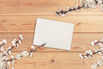 Blank white paper card with fresh flower on desk