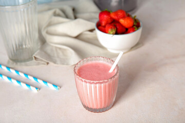 Fototapeta na wymiar Glass of tasty strawberry smoothie on light background