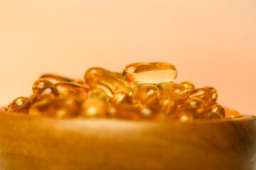 Fish oil capsules in a wooden cup .Omega fatty acids in jelly capsules.Dietary supplements and...