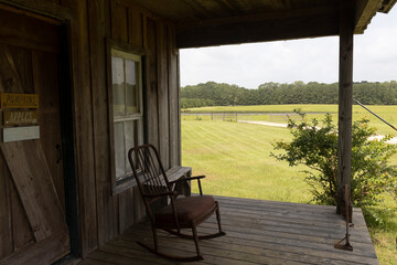 Country cabin porch in pastoral setting.