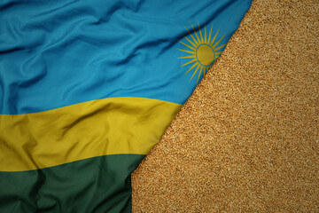 wheat grain on the waving colorful big national flag of rwanda .