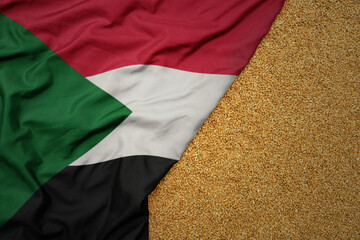 wheat grain on the waving colorful big national flag of sudan .