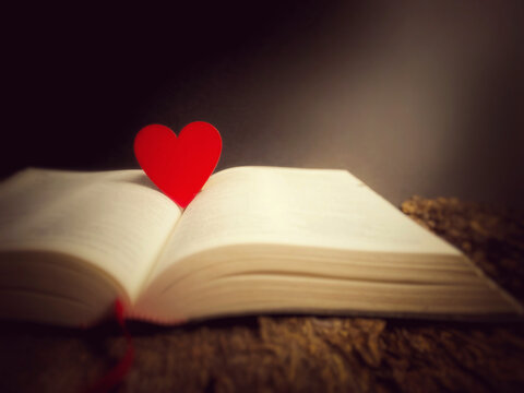 A red heart in vintage background. With opened bible. Christian faith hope love concept.