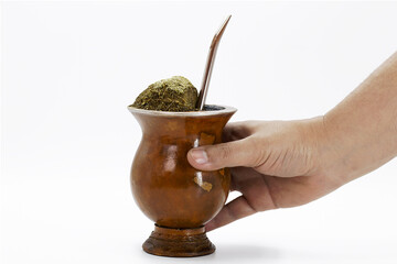 hand holding cup of mate, called chimarrão, from South America. Isolated white background, yerba...