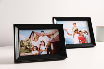 Frames with family photos on white table