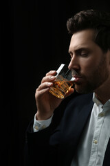 Man in suit drinking whiskey on black background