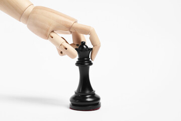 Robot with black chess piece on white background. Wooden hand representing artificial intelligence