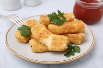 Plate with tasty fried mozzarella sticks and parsley on light table, closeup