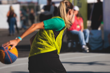 Female athletes play basketball, teenage team play street basketball, players on the outdoor basketball court venue, sports team during the game, playing match game in a summer sunny day