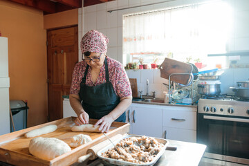 Unrecognizable Latin Elderly Woman Kneading Dough with Hands and Rolling Pin in Her Countryside...