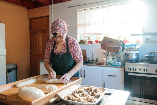 Unrecognizable Latin Elderly Woman Kneading Dough with Hands and Rolling Pin in Her Countryside Kitchen