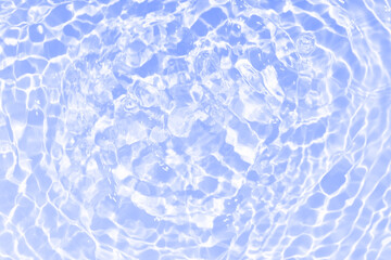 Blue water with ripples on the surface. Defocus blurred transparent blue colored clear calm water surface texture with splashes and bubbles. Water waves with shining pattern texture background.