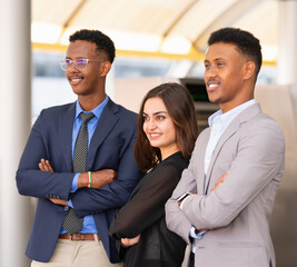 portrait of businesswoman smile, cross arm, standing with collegue while working outside building in city. caucasian woman in black suit, black men in blue and grey suit