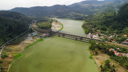 Aerial drone view of railroad bridge with view of mountain river and trees