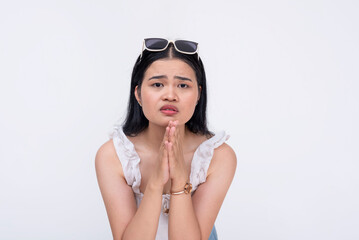 A desperate and vulnerable woman begging for help and protection from someone. A damsel in distress pleading with clasped hands and submissive eyes. Isolated on a white background.