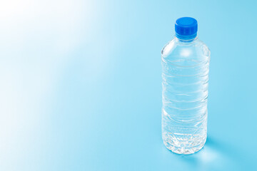 Naklejka premium 青背景にペットボトルの水