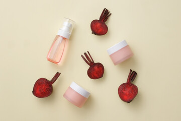 Against beige background, halves of fresh beetroot displayed with two jars and a bottle without label. Beetroot (Beta vulgaris) contains a lot of vitamin C