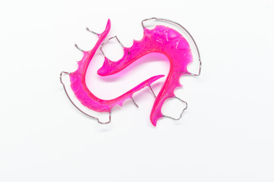 Pink Hawley retainer, translucent, orthodontics, isolated on white background, selective focus