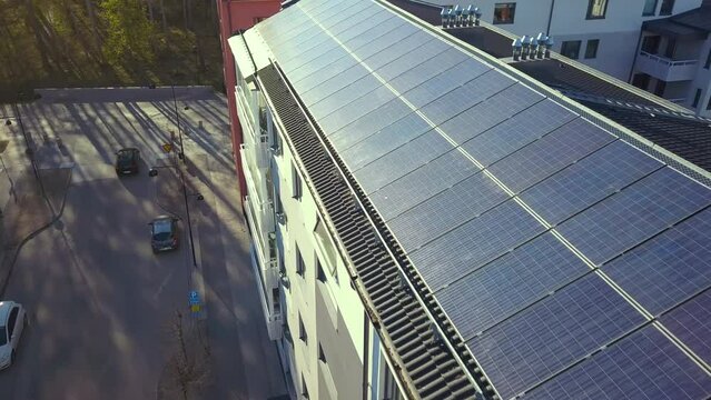 Renewable electricity development. Solar photovoltaic panels mounted on roof of swedish condo building in Linkoping residential area