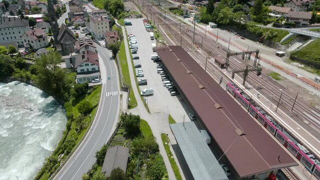 Cinematic Drone View of small village featuring Franzensfeste Train Station near the Eisack River and vibrant green vegetation scenery