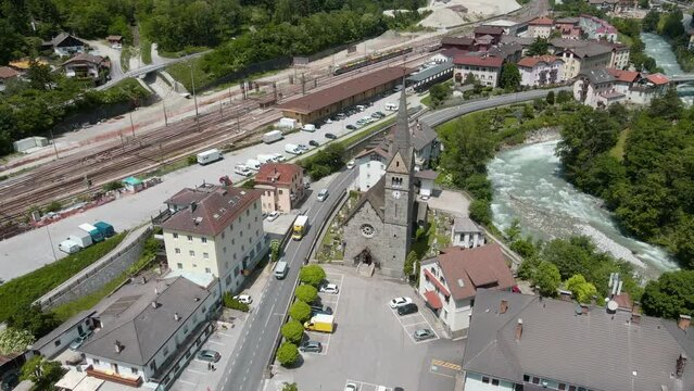 Cinematic Arial View of small village featuring Franzensfeste Church and Train Station near the Eisack River