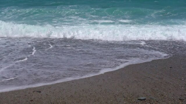 Slow motion video of small stormy waves crashing onto the sand in Looc Beach. Surigao City Philippines.