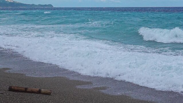 Small stormy waves caused by a low pressure area crash on to the beach at Looc Village, Surigao City. Philippines.