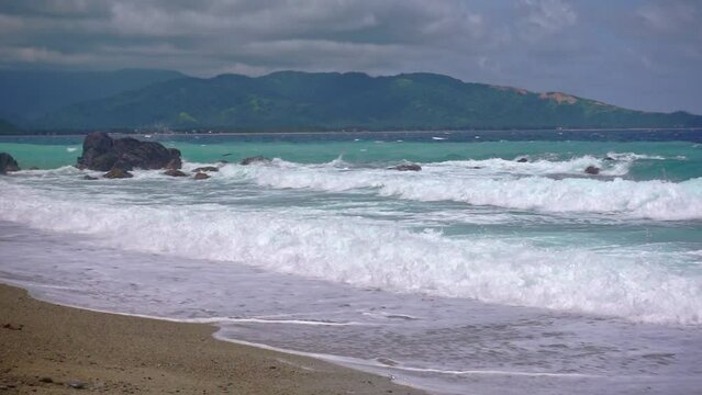 Slow motion video of Small stormy waves caused by a low pressure area crash on to the beach at Looc Village, Surigao City. Philippines.