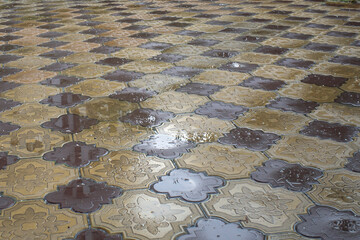 Wet pavement made of tiles on an autumn day