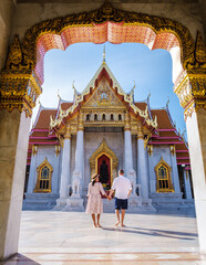 Wat Benchamabophit temple in Bangkok Thailand, The Marble temple in Bangkok. Asian woman with a hat and European men visiting a temple, a couple on a city trip in Bangkok