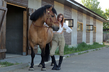 Model country girl posing with horse near the stable