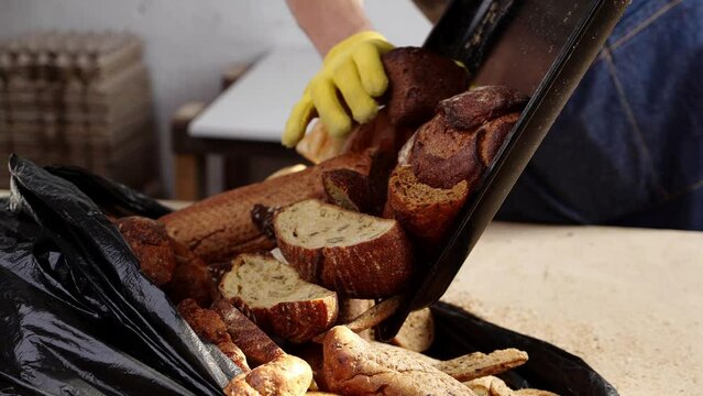 Baker throws unsold bread in the trash. Bakeries waste. Repurposing discarded dough