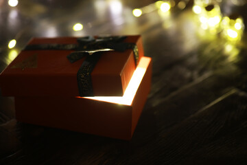 Gift boxes against a background bokeh of twinkling party lights. Luxury New Year gift. Christmas...