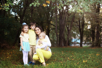 Family with children for a walk in the summer park. Сoming autumn in the park. Family. Fall. Happiness.